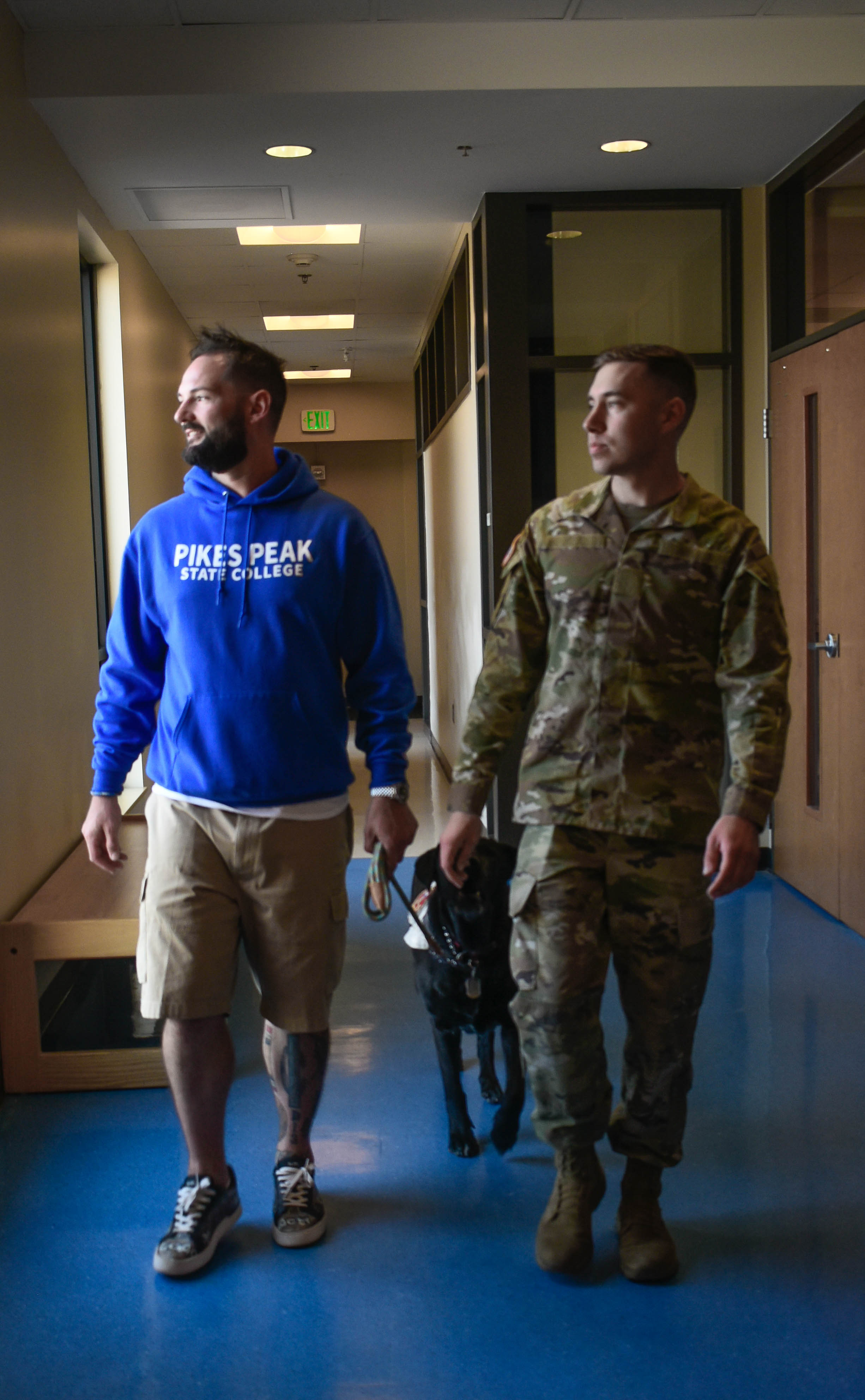 military student in uniform walking with another student