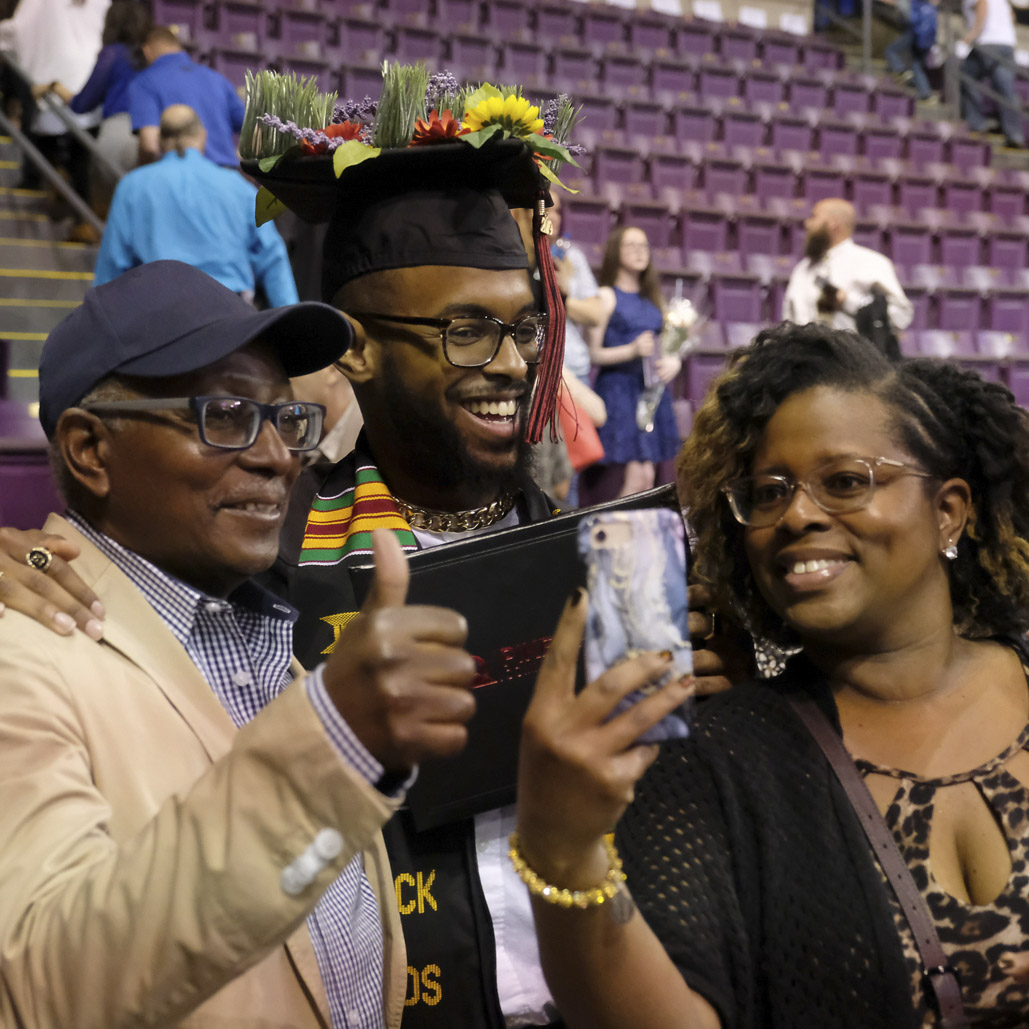 student with family at commencement ceremony