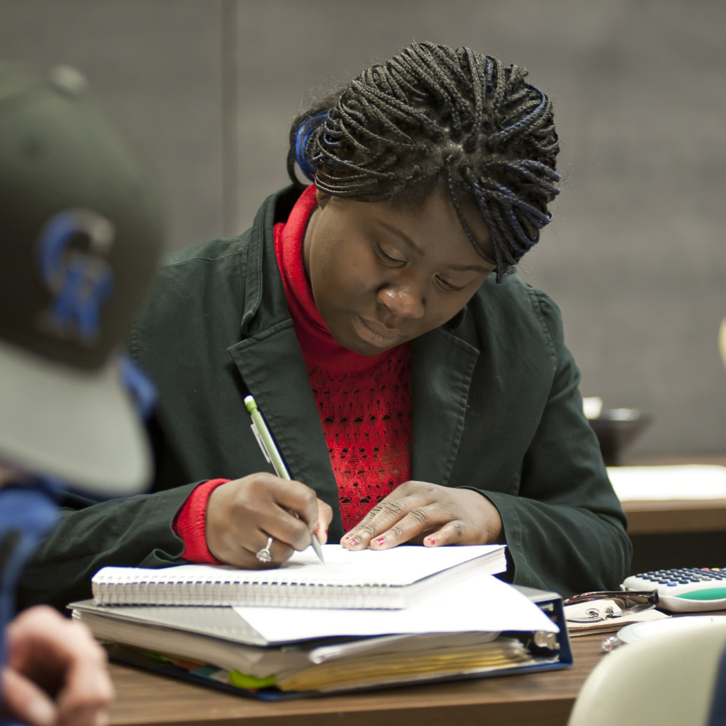 Student taking notes in class.