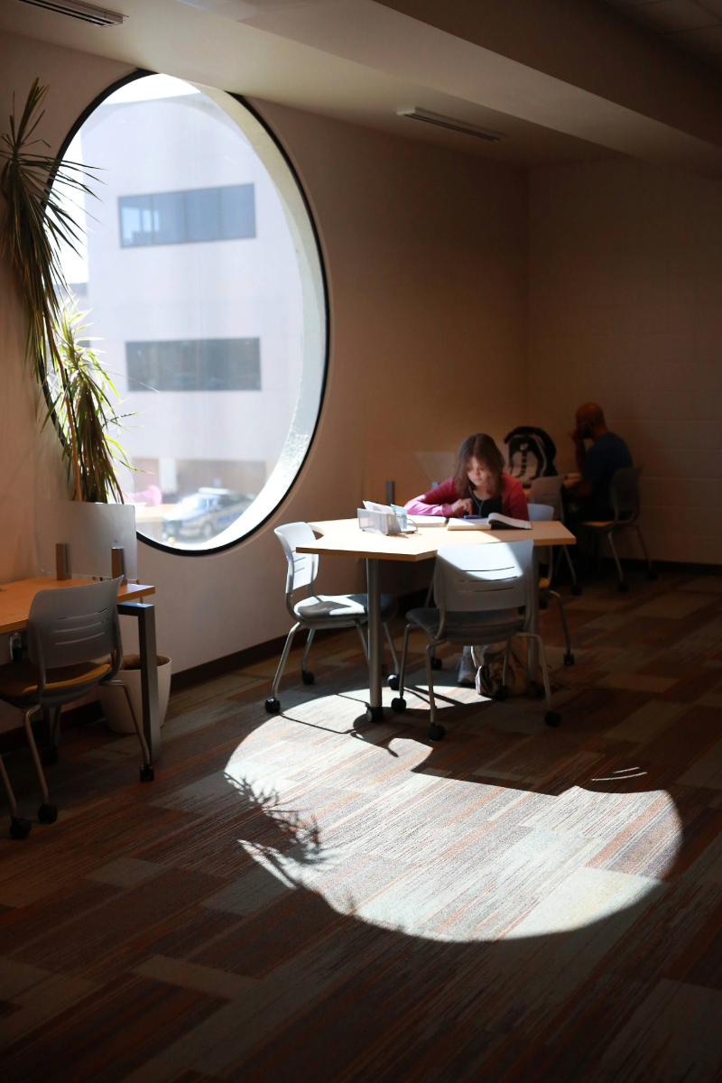 students studying near round window on campus