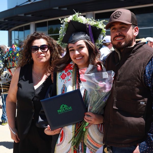 Graduate in cap and gown celebrating with family at commencement