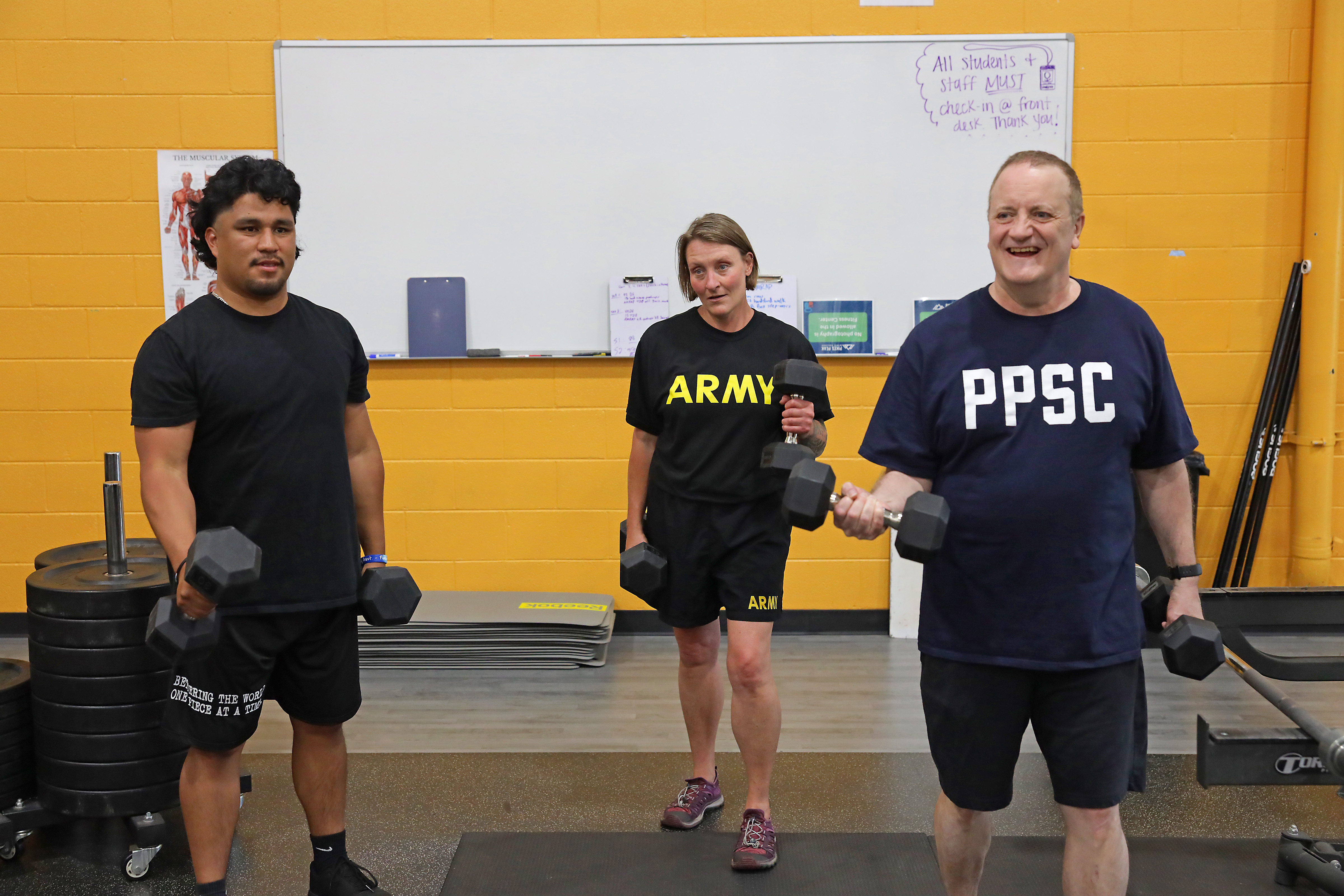 3 students lifting weights in the fitness center
