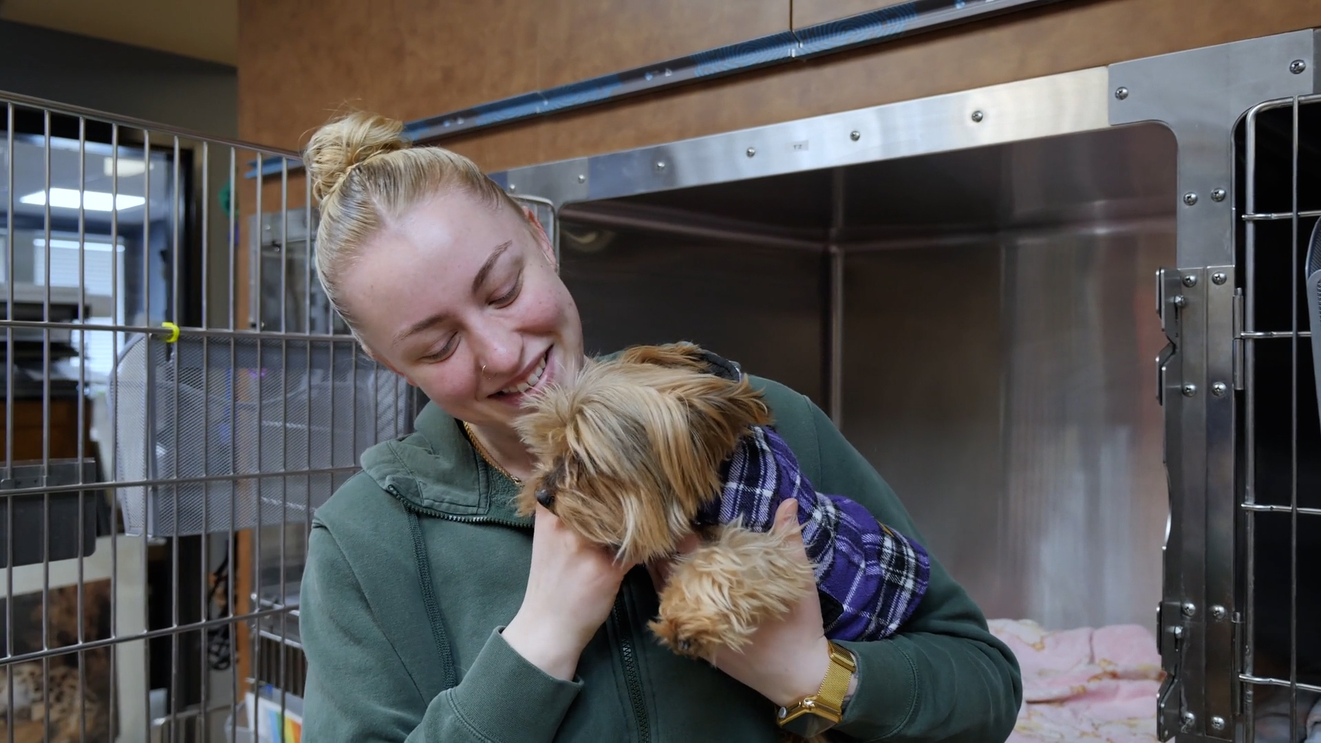 female student with a puppy in front of a kennel